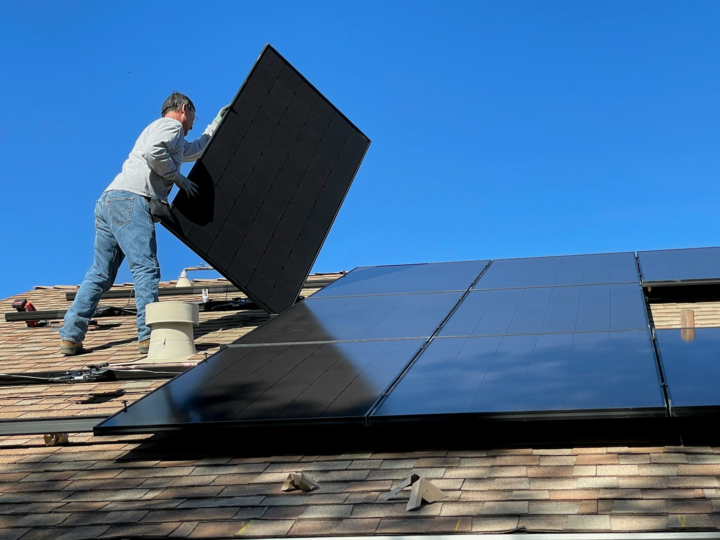 Installateur legt een zonnepaneel op een dak